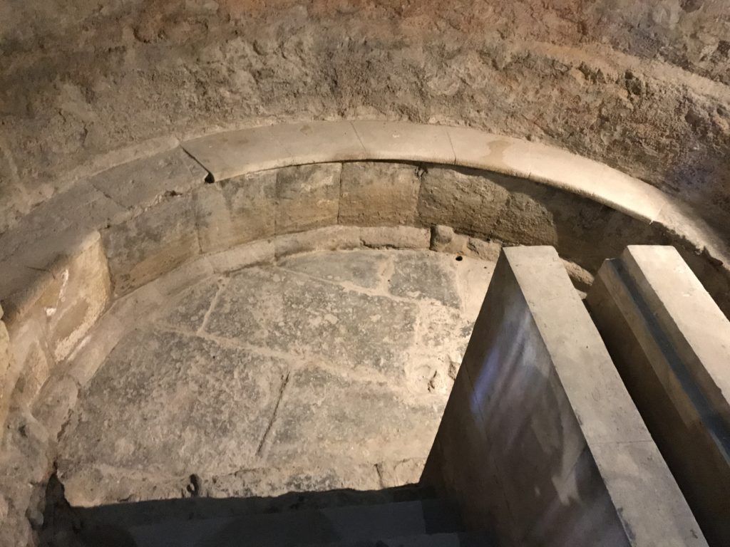 A semi-circular, step-down bath in one of the inner rooms at the Roman Baths at Bath