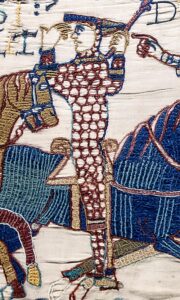 When his horse falls, William jumps upright and lifts the visor of his helmet, to reassure his army that he's still alive. A scene from the Battle of Hastings in the Bayeux Tapestry.
